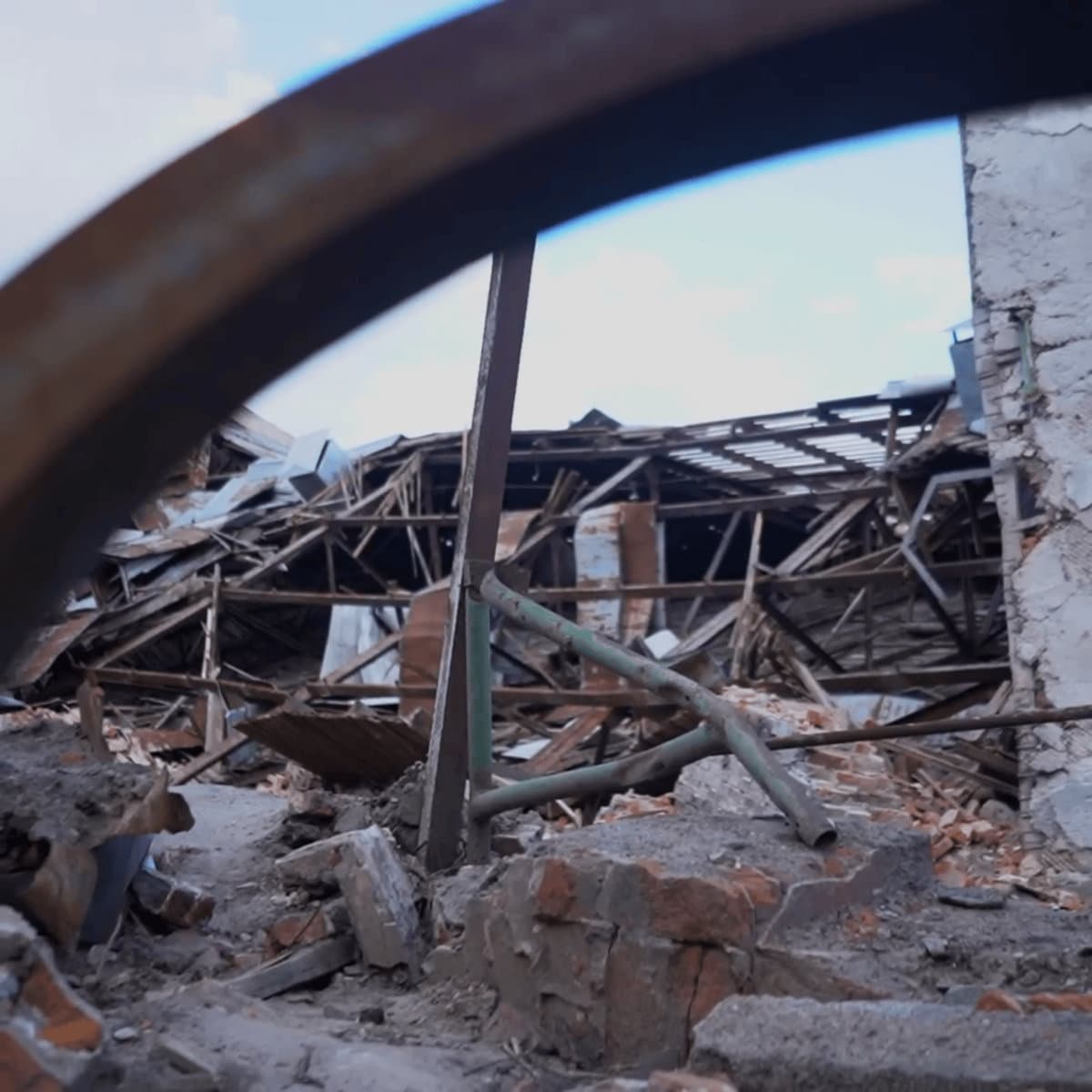Circumstance cover: a rusted steel arch framing the collapsed roof of a brick building under a pale sky